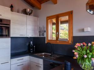 a kitchen with a sink and a vase of flowers at Chalet Dolce Cabane by Interhome in Nendaz