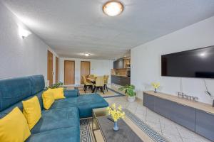 een woonkamer met een blauwe bank en een flatscreen-tv bij Holiday House Aida with Private Pool in Buzet