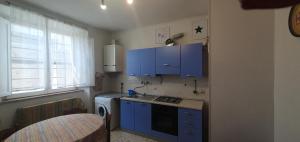 een kleine keuken met blauwe kasten en een wastafel bij CASA MAREA Appartamento 1 in Grottammare