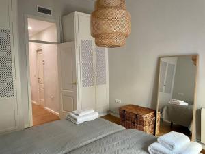 sypialnia z łóżkiem z lustrem i koszem w obiekcie 7R Charming Apartament Downtown Sevilla w Sewilli