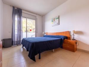 a bedroom with a blue bed and a window at Apartment Aquaria-5 by Interhome in Salou