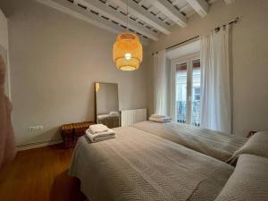 sypialnia z dużym łóżkiem i dużym oknem w obiekcie 7R Charming Apartament Downtown Sevilla w Sewilli