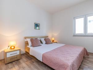 sypialnia z dużym łóżkiem i oknem w obiekcie Apartment Maja-3 by Interhome w mieście Maslenica