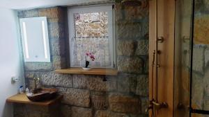 a bathroom with a window and a stone wall at Das Ferienhaus Protze in Hohnstein