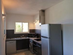 uma cozinha com um frigorífico e um lavatório em Villa Villa Orizonte by Interhome em Favone
