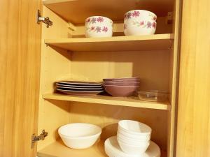 a cupboard with bowls and plates in it at Cozy Nights SVP Detached House in Nitshill