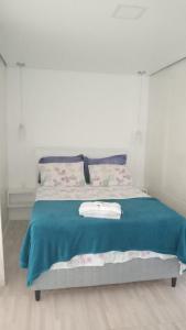 1 dormitorio con 1 cama con manta azul en Villas de Portugal - Praia do Ervino, en São Francisco do Sul
