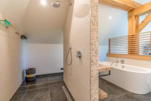 a bathroom with a shower and a tub and a sink at Buytenplaats Villa 193 in De Koog
