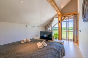 a bedroom with a bed with a flat screen tv at Buytenplaats Villa 193 in De Koog