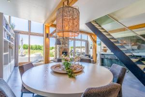 a dining room with a table and a chandelier at Buytenplaats Villa 193 in De Koog