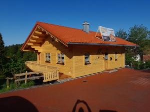 une maison avec un toit rouge sur un tas dans l'établissement Holiday Home Chalet Toni mit Sauna by Interhome, à Spiegelau