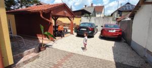 ハイドゥソボスローにあるFortuna Apartmanの家の出入り口に立つ幼児