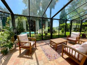 a conservatory with chairs and a table and glass walls at Villa Sofia by Interhome in Sirtori