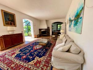 een woonkamer met een witte bank en een tapijt bij Villa Sofia by Interhome in Sirtori