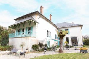 an old white house with tables and chairs at Le Moulin Chambres hôtes in Montréal La Cluse