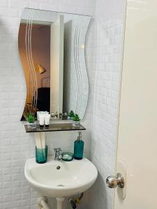 Gillera Staycation in Lipa في ليبا: حمام مع حوض ومرآة