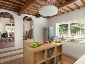 a kitchen with white cabinets and a wooden ceiling at Villa Oliva by Interhome in Querce