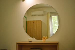 a bathroom with a round mirror on the wall at The Little House in Glífa