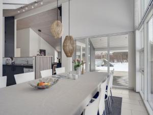a kitchen and dining room with a table and chairs at Holiday Home Asel - 4km from the sea in NW Jutland by Interhome in Brovst