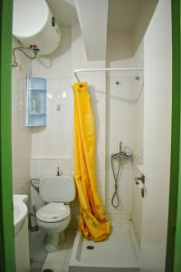 a bathroom with a shower with a yellow shower curtain at The Little House in Glífa