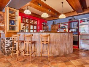 a kitchen with a bar with wooden stools at Chalet Krakonoš by Interhome in Mladé Buky