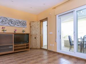 ein Wohnzimmer mit einem TV und einer Glasschiebetür in der Unterkunft Holiday Home Peñismar II-1 by Interhome in Peñíscola