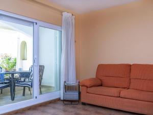 ein Wohnzimmer mit Couch und Balkon in der Unterkunft Holiday Home Peñismar II-1 by Interhome in Peñíscola + 12 Fotos