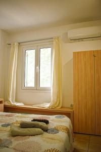 1 dormitorio con cama y ventana en The Little House, en Glifa