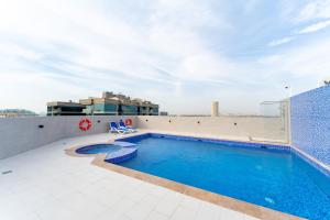 a swimming pool on the roof of a building at Large 2BR w Wooden floor 2 min Access Highway in Dubai