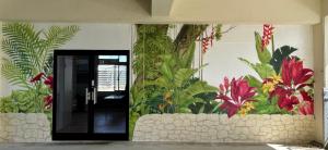 Habitación con un mural de plantas en la pared en SumiwaHouse, en Yomitan