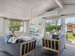 a living room with a couch and chairs and windows at Holiday Home Amy - 150m from the sea in Funen by Interhome in Otterup