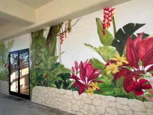 un mural de flores en una pared en SumiwaHouse, en Yomitan