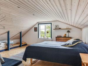 ein Schlafzimmer mit einem großen Bett und einer Holzdecke in der Unterkunft Chalet Smedstorp - VGT130 by Interhome in Tibro
