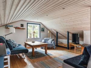 ein Wohnzimmer mit Holzdecke in der Unterkunft Chalet Smedstorp - VGT130 by Interhome in Tibro