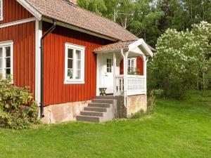 ein rotes Haus mit einer weißen Tür und einer Treppe dahin in der Unterkunft Chalet Smedstorp - VGT130 by Interhome in Tibro