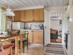 a kitchen with wooden cabinets and a table in a room at Chalet Smedstorp by Interhome in Tibro