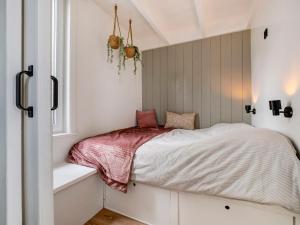een bed in een kamer met een raam bij Holiday Home Harboursuite incl- boot-2 by Interhome in Woudsend