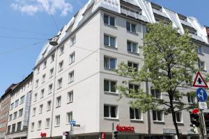 a white building on the corner of a street at MUNICH FINEST APARTMENTS in Munich
