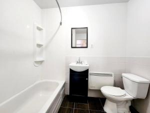 a bathroom with a toilet and a sink and a tub at Loft bien situé pour découvrir Vieux-Québec! in Quebec City
