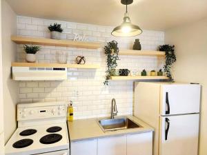 a kitchen with a white refrigerator and a sink at Loft bien situé pour découvrir Vieux-Québec! in Quebec City