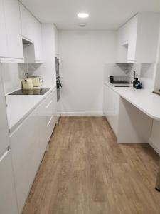 uma cozinha branca com pisos em madeira e armários brancos em SeaSky em Portland