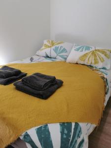 uma cama com um cobertor amarelo e almofadas em SeaSky em Portland