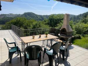 a table and chairs on a patio with a wood stove at Traumhaus am Wald 1 in Weiersbach