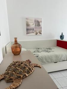 a room with a bed and a table with a vase at La Rochelle sur l'eau - Studio in La Rochelle