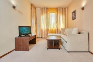 a living room with a couch and a tv at Casablanca Hotel - All Inclusive in Obzor