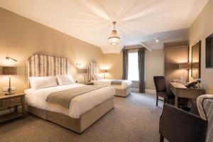 een hotelkamer met 2 bedden en een bureau bij The Salthouse Hotel in Ballycastle