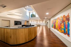 an office lobby with a large painting on the wall at Iberik Gran Balneario de Guitiriz in Guitiriz