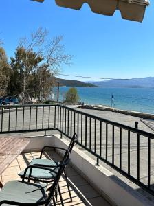 a couple of chairs sitting on a balcony overlooking the water at The Little House in Glífa