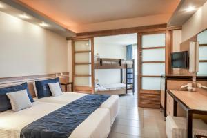 a hotel room with a bed and a tv at Esperides Beach Resort in Faliraki