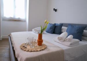 una mesa con toallas y un jarrón con flores. en Vaaz Rooms, en Sannicandro di Bari